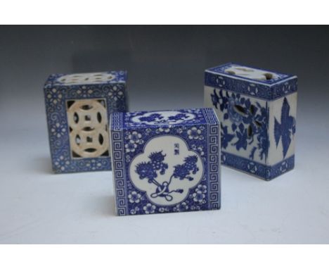A COLLECTION OF THREE ORIENTAL BLUE AND WHITE CERAMIC PILLOWS, of typical form, one decorated with Dogs of Foe tugging agains