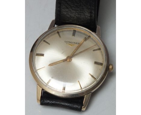 A GENTS 9CT GOLD LONGINES WRISTWATCH, manual wind, champagne dial with hourly baton markers, on black leather strap, engraved