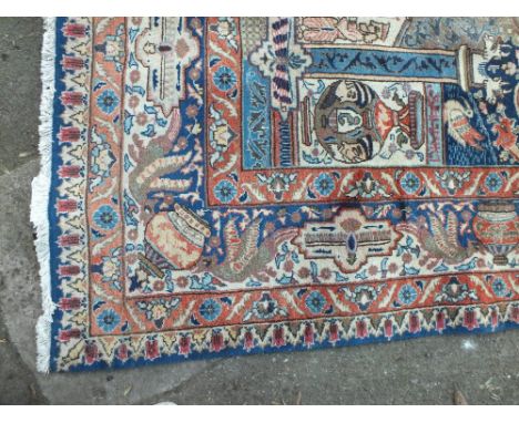 A LARGE EASTERN WOOLLEN EARLY 20TH CENTURY RUG / CARPET, the central cartouche with figurative detail, further architectural 