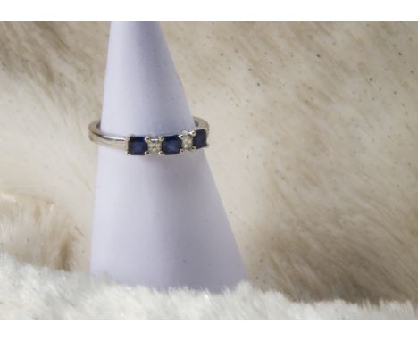 A modern 18ct white gold sapphire and diamond five stone ring, three square cut blue stones enclosing two princess cuts, 3.9g