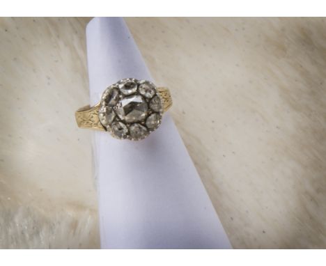 A Georgian diamond cluster ring, flower head tablet having a larger rose cut stone surrounded by eight smaller examples, on a