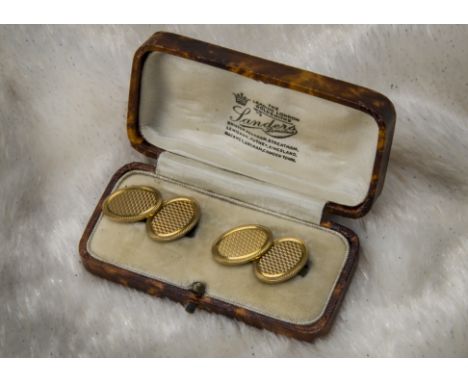 A pair of vintage 9ct gold cufflinks, having engine turned oval panels joined by chains, 12g, with a retailers box (3) 