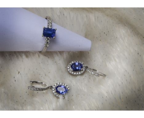 A modern tanzanite and diamond ring and pair of earrings, the 18ct white gold ring having rectangular cut blue stone and thre