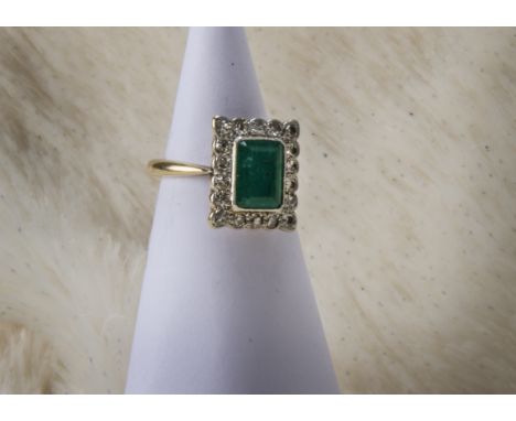 An Art Deco period emerald and diamond cluster ring, the rectangular platinum tablet set with eight cuts and central green st