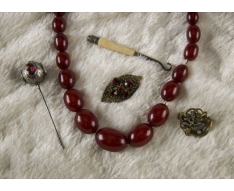 An Art Deco cherry amber style bead necklace, together with a silver and paste set hatpin, AF, a button hook, a brooch and a 