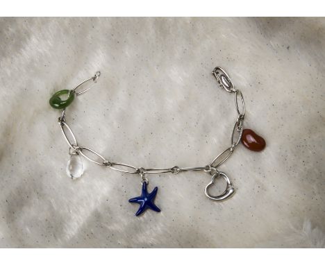 A modern silver charm bracelet from Tiffany & Co, designed by Elsa Peretti, with carnelian coffee bean, heart, blue enamelled