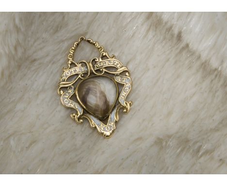 A Georgian gold and enamel sweetheart or mourning pendant, the shaped and pierced mount with ribbon style Latin motto and cen