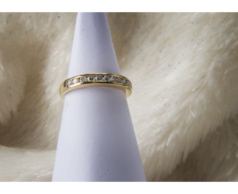 A modern 18ct gold and diamond half hoop eternity ring, having eleven channel set brilliant cuts, 2.8g and size K 