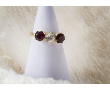 An 18ct gold gem set three stone ring, having a white topaz and pair garnets, marked 18ct, 4.4g and size S 