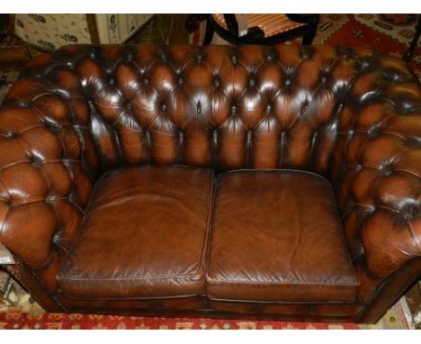 A brown leather Chesterfield sofa. H.73cm W.150cm D.94cm