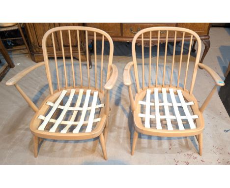 A pair of Ercol beech and elm arm chairs with rounded stick backs.