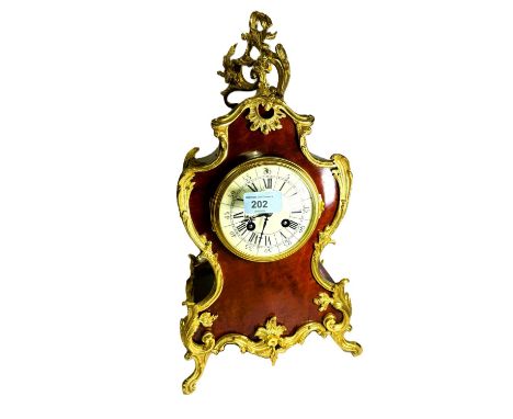 A Louis XV style gilt metal and tortoiseshell effect Rococo mantel clock with white dial, and striking movement on scroll fee