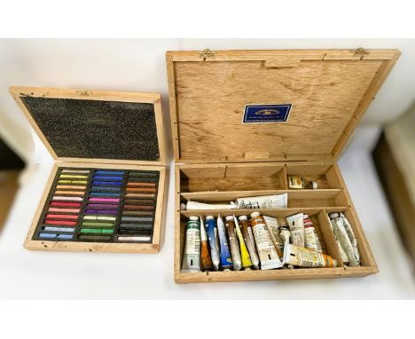An artists easel and a selection of artist's paints and requisites.