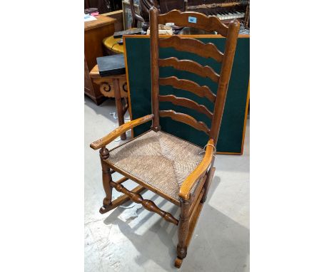 A 19th century ladder back rush seat rocking/nursing chair.
