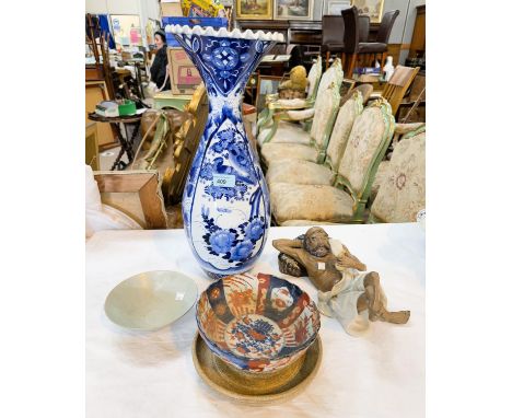A tall Chinese blue and white vase with flared wavy rim decorated with panels of foliage and birds etc; a pottery reclining f