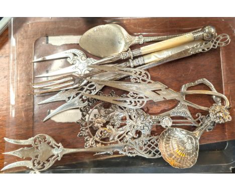 A silver toast fork and a selection of white metal caddy spoons, forks etc