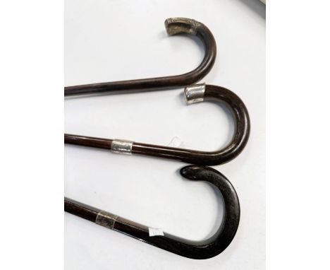 A vintage square section rosewood walking stick with silver mount, 92 cm, and two similar sticks (3).