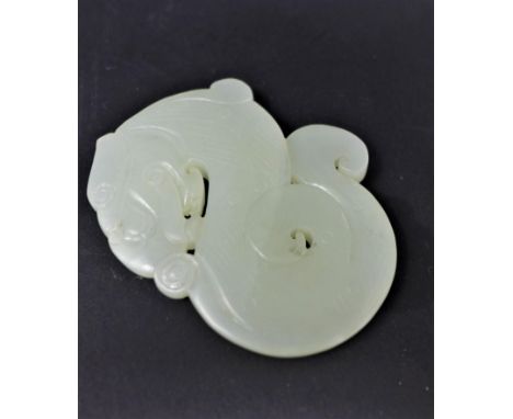 A Chinese pale green carved jade pendant depicting a stylised serpent, 6 x 5cm, 41.8g 