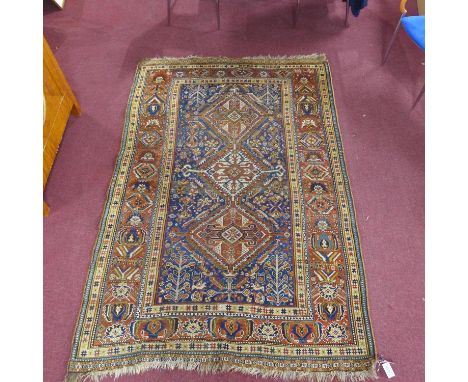 An antique Qashqai carpet with 3 geometric medallions, surrounded by geometric floral motifs on a blue ground, contained by g