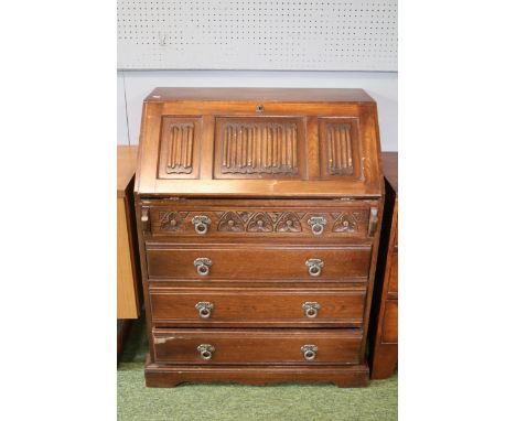 A Wood Brothers "Old Charm" Fall Front Bureau of Linenfold front Over Four Drawers With Metal Drop Loop Handles, Carved Flora