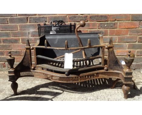 An Empire style bowfront fire grate with steel urn finials, 101cm wide, a pair of Arts &amp; Crafts style andirons, a Victori