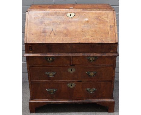 An early 18th century walnut cross and feather banded bureau, with a moulded caddy top, the fitted stepped interior having a 