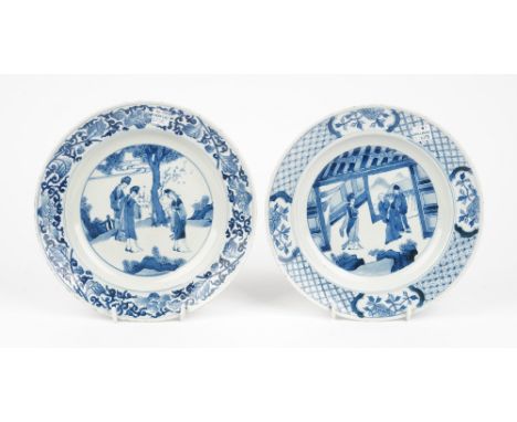 A Chinese blue and white plate in Kangxi style, painted with a central figurative panel inside a diaper border reserved with 