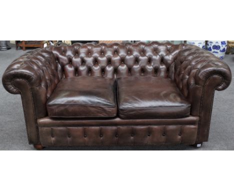 A brown leather upholstered button back Chesterfield sofa on bun feet, 175cm wide x 70cm high. 