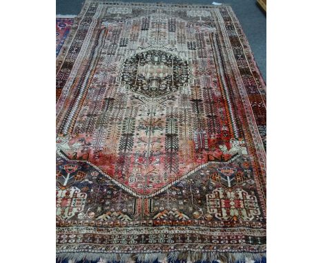 A Ghasghai Persepolis carpet, South Persian, the madder field with a brown medallion, all with angular flowering stems; match