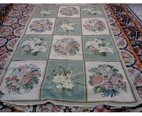 A Portuguese chain stitch needlework carpet with three x four panels in alternating green and ivory, each with a floral bouqu