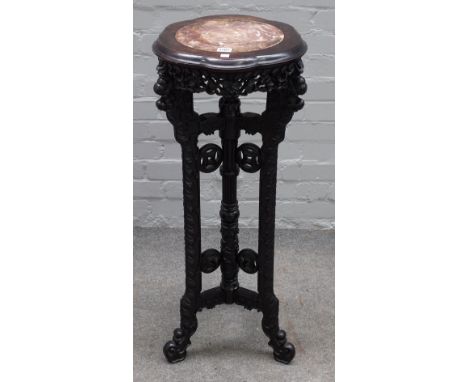An early 20th century Chinese jardiniere stand, the shaped marble inset top over carved hardwood base, 37cm diameter x 92cm h