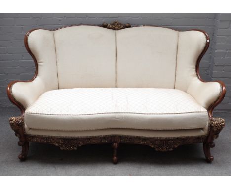 An 18th century Italian style parcel gilt mahogany sofa, with shaped back and scroll supports, 180cm wide x 99cm high. 