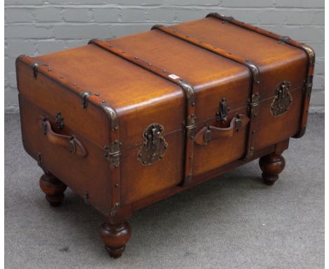 A coffee table formed as a wood and leather bound travelling trunk, on turned feet, 90cm wide x 56cm high. 