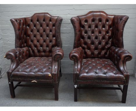 A pair of early 18th century style shaped wing back armchairs, with brown leather button upholstery on block supports, 85cm w
