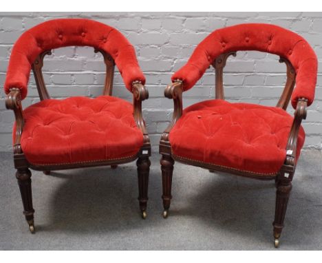 A pair of Victorian walnut frame library armchairs, circa 1870, with button down upholstered curved open backs and stuff-over