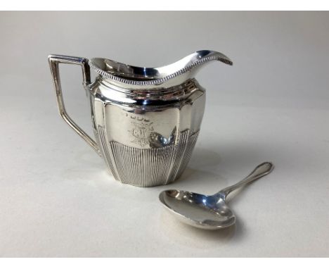 A Victorian silver cream jug, maker Florence Warden, Chester 1895, monogrammed, together with a silver caddy spoon, maker Mar