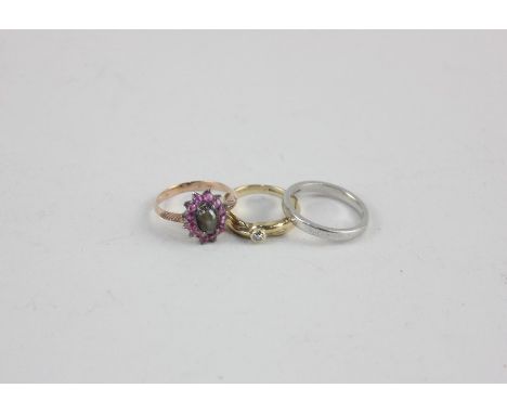 A platinum wedding ring 5.6g; a diamond single stone ring in 9ct gold; a cabochon star corundum within a pale ruby border rin