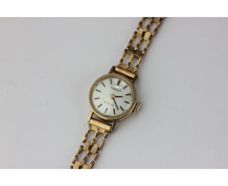 A lady's 9ct gold Tissot watch on a associated bracelet