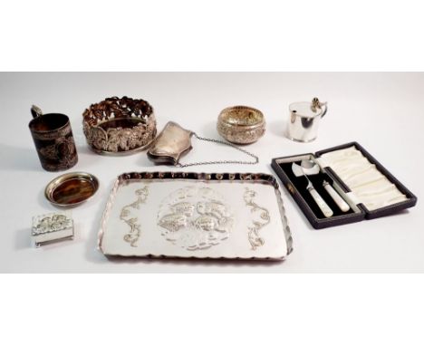 A group of silver plated items including embossed angel heads dressing table tray and trinket box, vine bottle coaster, eveni