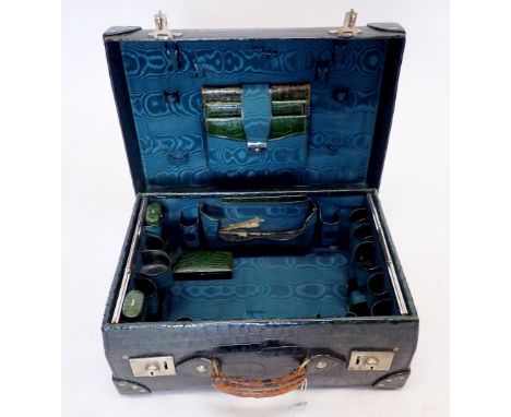 A dark green leather gentleman's travelling suitcase fitted with correspondence folders, inkwell, pen holders, cigarette ligh