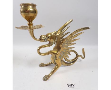 A brass Wyvern candlestick with red glass eyes, 16cm wide