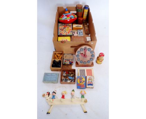 A box of various games and child related items including a Chad Valley wooden clock, various card games, cribbage, wooden che