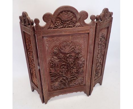 An Eastern heavily carved folding fireplace guard or screen, 101cm high