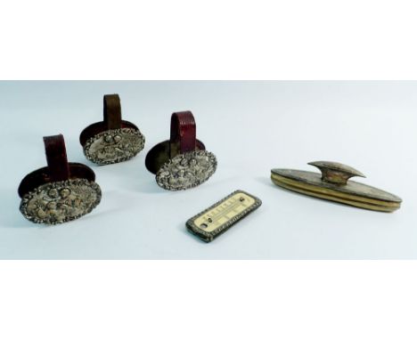 A set of three silver and leather mounted metal clips embossed scenes of putti playing, Chester 1917 by James Deakin, 8.5cm t