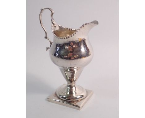 A George III silver cream jug with punched decoration to rim and square pedestal foot, London 1784, 11cm tall, makers mark ru