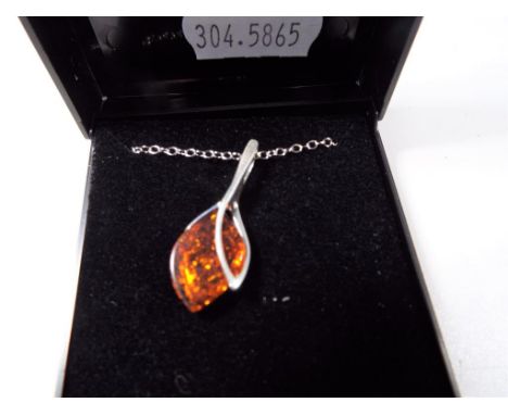 A silver pendant and chain, stone set with amber. Estimate £20 - £30   - This lot MUST be paid for and collected, or delivery