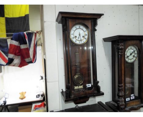 A slim Vienna-styled wall clock two-train gong striking movement, white enamel dial with Roman numerals, with grid-iron style