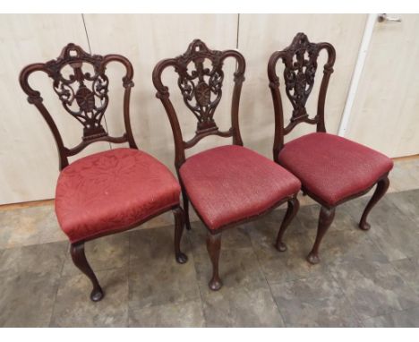 Three Chippendale style dining chairs with pierced and carved back splats, having red upholstered seats - This lot MUST be pa