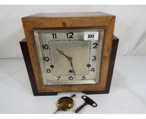 An Art Deco stair-stepped mantel clock, the silvered dial with Arabic numerals, Westminster chimes, German mechanical movemen