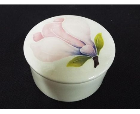 Moorcroft Pottery - a small round-lidded trinket box, decorated in the Pink Magnolia pattern, impressed marks to the base, ap